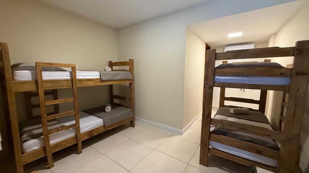 a room with three bunk beds in a room at Caminho de Itacoatiara in Niterói
