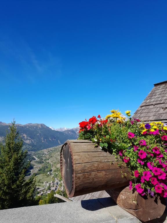 a wooden barrel filled with flowers on a roof at Casa Vacanze Ginger in Grange Sises