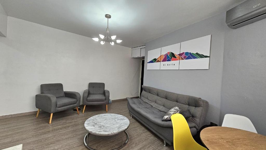 a living room with a couch and two chairs at Comodidades, modernidad, céntrico in Caracas
