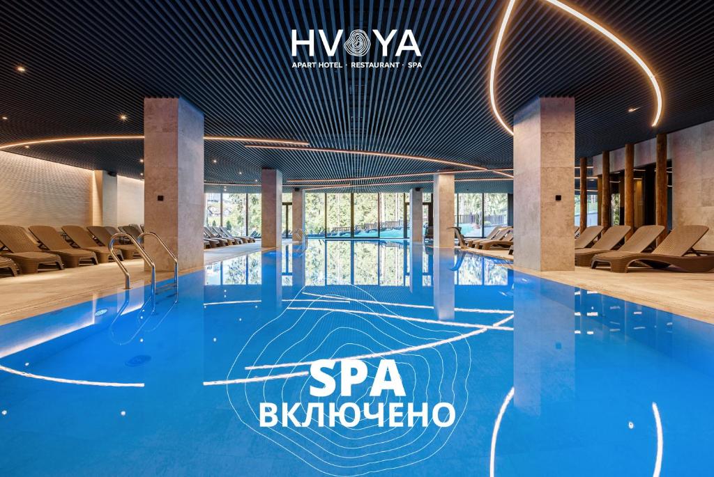 a swimming pool with chairs in a building at HVOYA Apart-Hotel & SPA in Bukovel