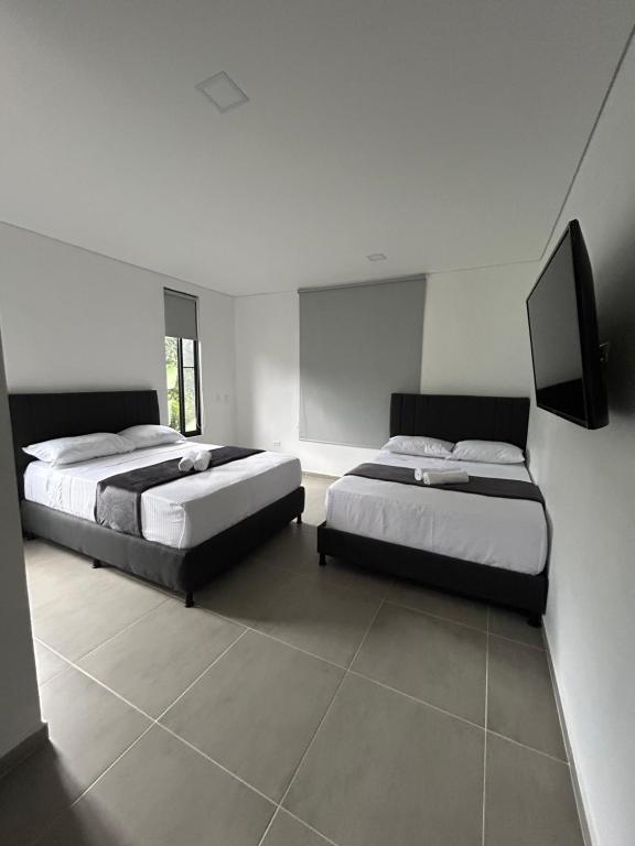 a bedroom with two beds and a flat screen tv at Dalusa House in Tena