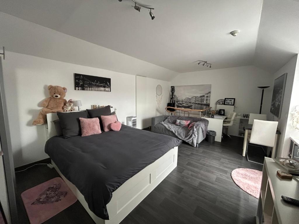 a bedroom with a bed with a teddy bear on it at La Vie est Belle chambre d hôte in Verviers