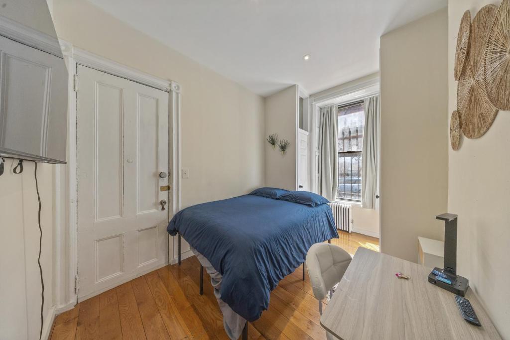 a small bedroom with a bed and a table at Times Square Retreat with Private Bathroom and Kitchenette in New York