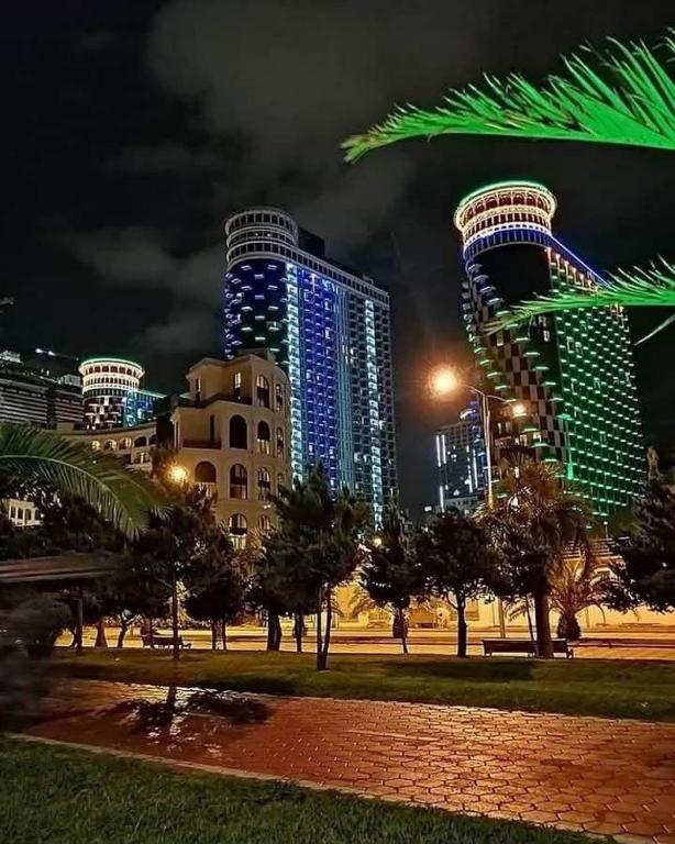 a city skyline with tall buildings at night at TOWERS Apartament in Batumi