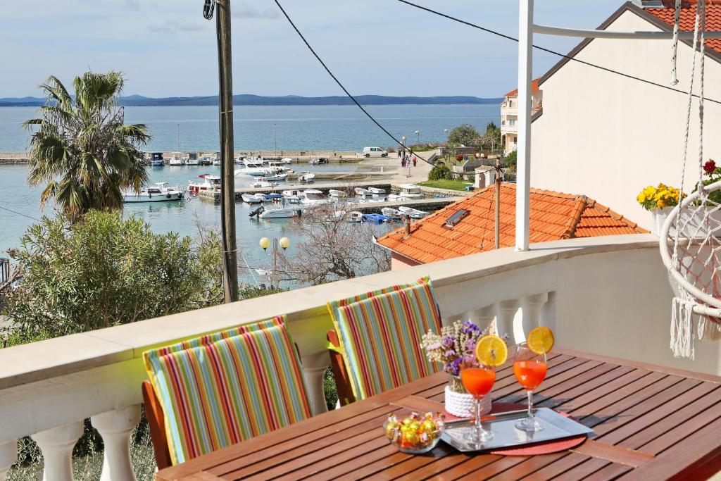 a table on a balcony with a view of a marina at Apartment Tea with Sea View in Petrcane