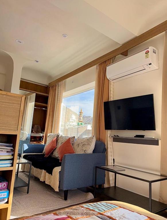 a living room with a couch and a flat screen tv at Cho Suites in Leh