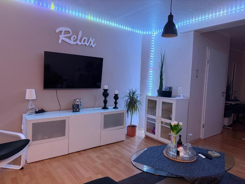 ein Wohnzimmer mit einem Fernseher auf einem weißen Entertainment-Center in der Unterkunft Wolke13 - gemütliche 2 Zimmer Wohnung mit voll ausgestatteter Küche in der City von Menden in Menden