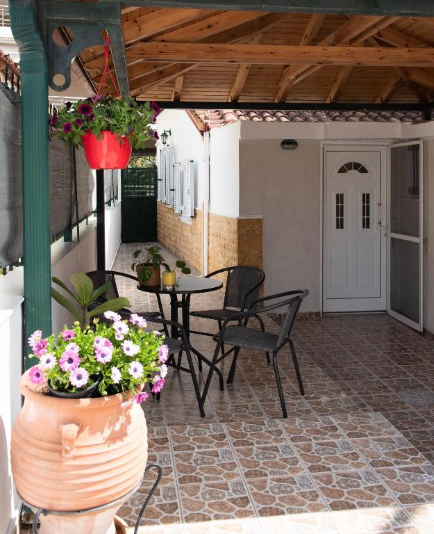 a patio with a table and chairs and flowers at Αυλή στην Μαρίνα in Kalamata