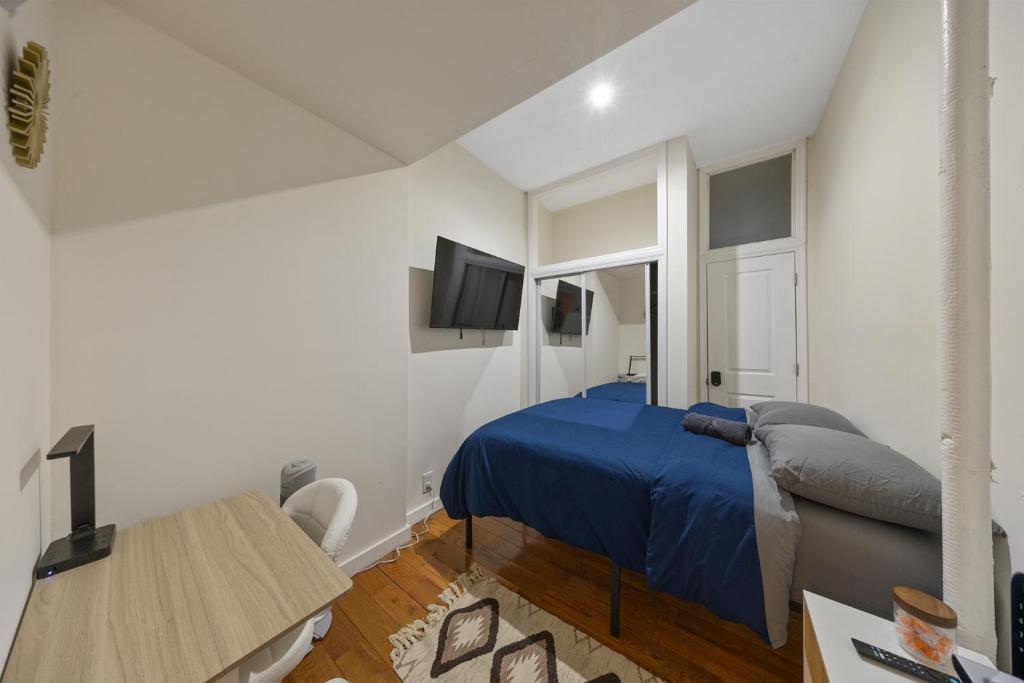 a bedroom with a bed and a desk and a tv at Private Room at a Shared Apartment by Times Square in New York