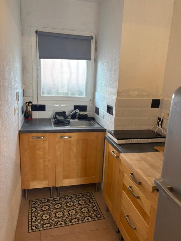 a small kitchen with a sink and a window at La maisonnette LMV in Sanary-sur-Mer