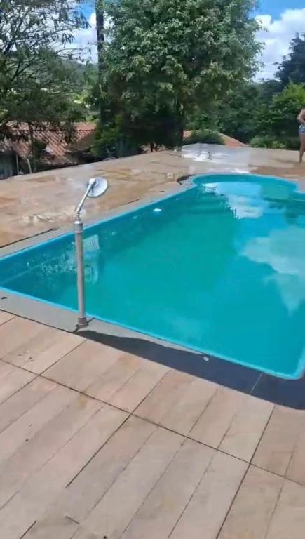 a swimming pool with a pole in the water at Sitio Walll in Sao Jose da Lapa