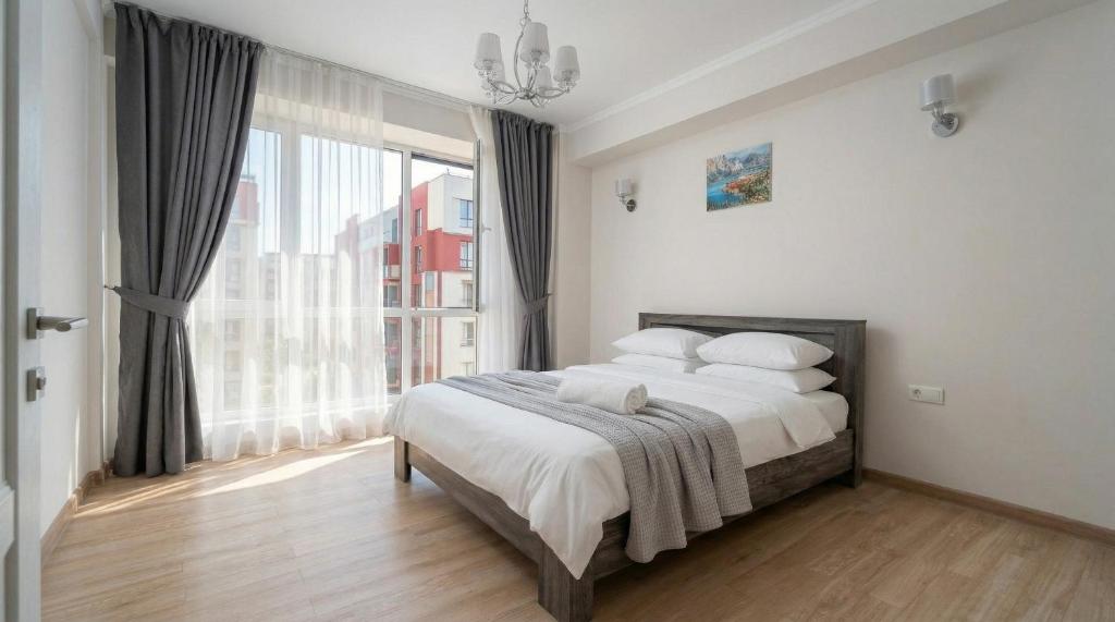 a bedroom with a bed and a large window at Cozy Almaty Escape in Almaty