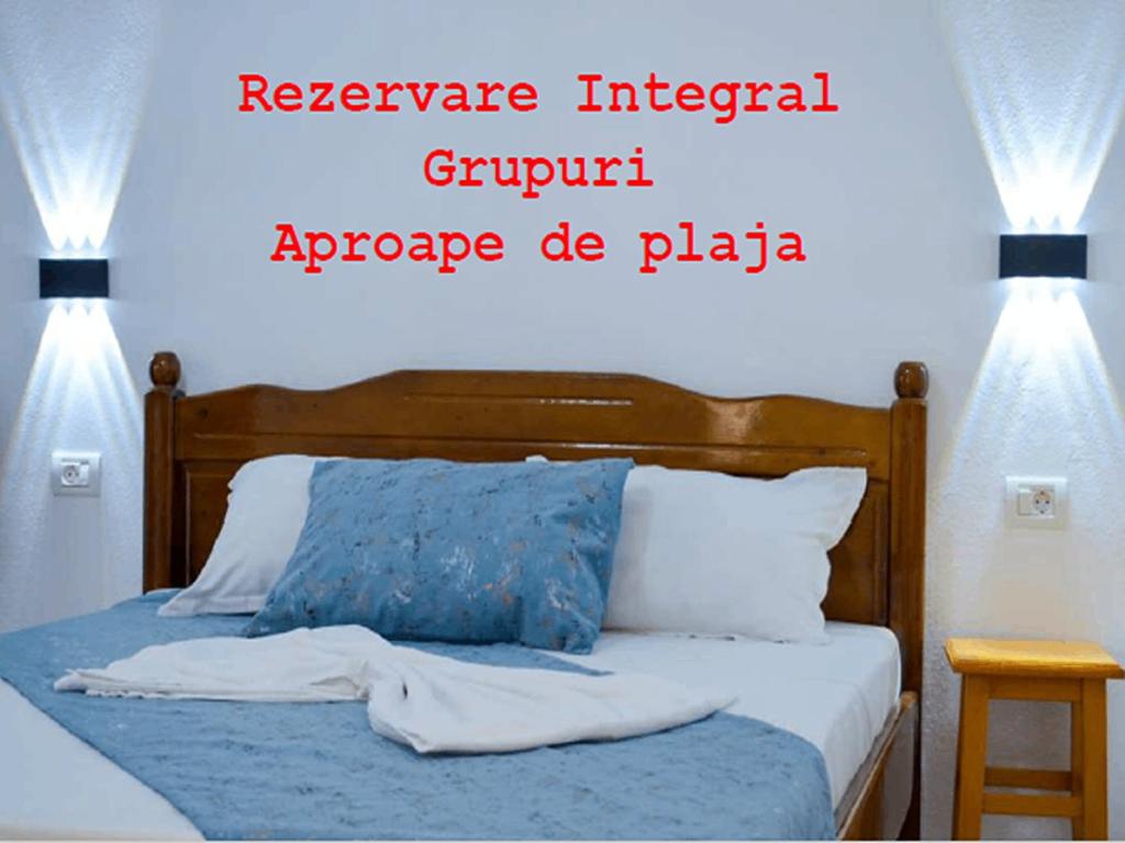 a bedroom with a bed with two lights on it at VIP next TIME Casa Vacanta in Costinesti