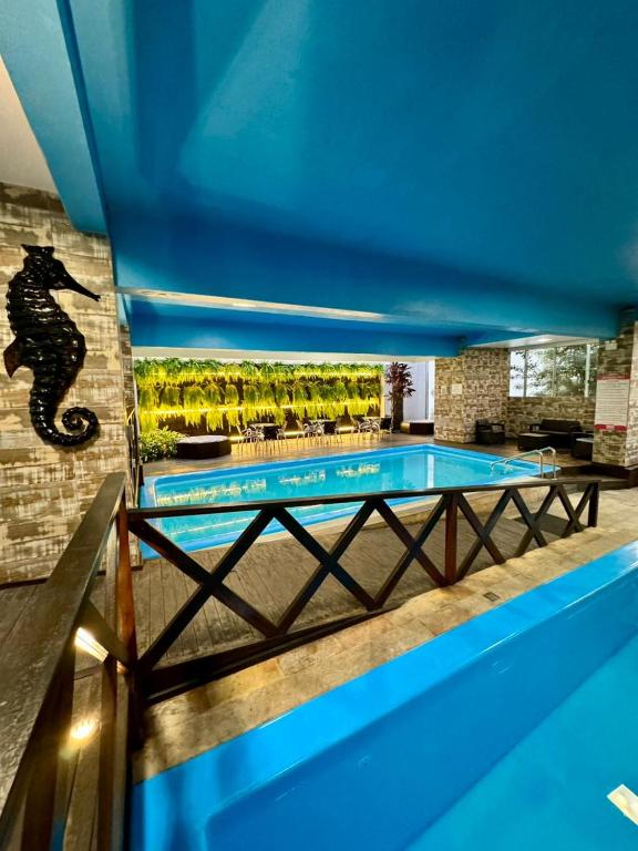 a swimming pool with a mermaid painted on the wall at Hotel Rieger in Balneário Camboriú