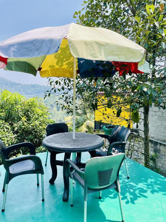 a table and chairs with an umbrella on a patio at Kandy Green HillTop Hotel in Kandy
