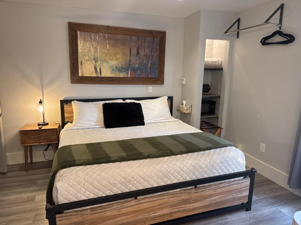 a bedroom with a bed with a black pillow on it at Eagle’s Landing Lodge in Custer