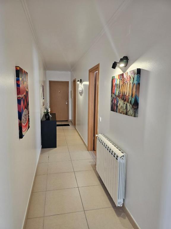 a hallway with a radiator and paintings on the wall at Brisa do Mar in Leiria