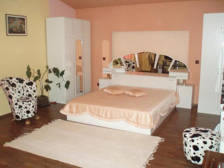 a bedroom with a bed and a mirror and a chair at Hotel Paradise in Kyustendil