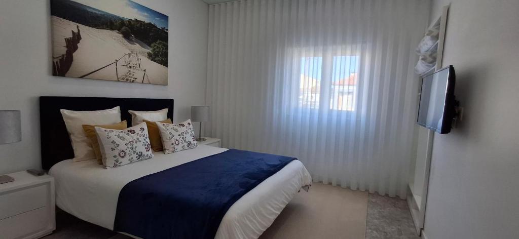 a bedroom with a large bed and a television at Ribeiro´s House in Gafanha da Nazaré