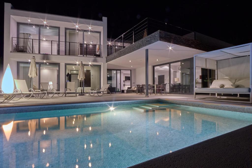 a swimming pool in front of a house at night at Can Anara in Cala Llena