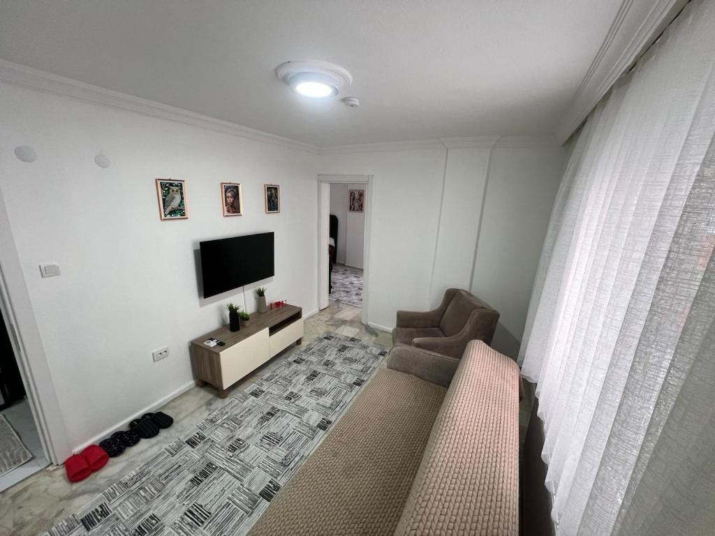 a living room with a couch and a flat screen tv at BR Konaklama in Göztepe