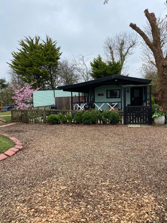 a house with a porch and a gravel driveway at Cherry Croft Lodge in Little Singleton