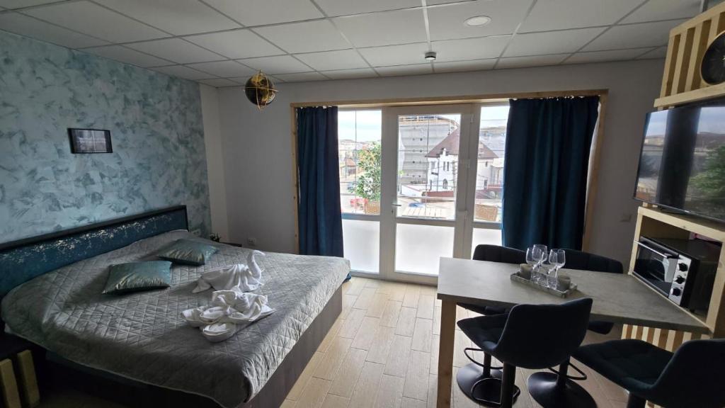 a bedroom with a bed and a table with chairs at Totall Panoramic Studio in Moreni