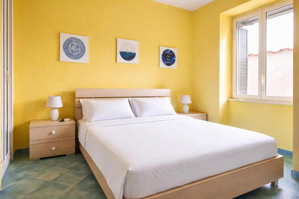a bedroom with a white bed and a window at Variopinto Home in Ischia Town