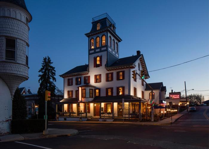 a large white building with a clock tower on a street at The Washington House Hotel & Restaurant in Sellersville