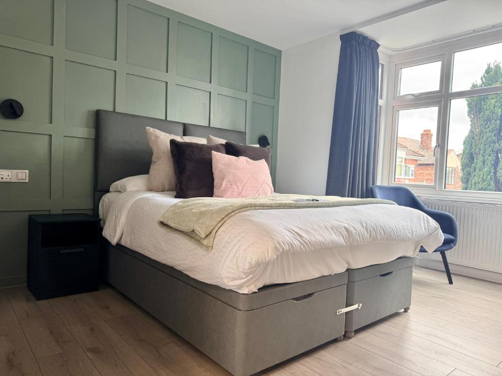 a bedroom with a large bed with pink pillows at United Home B&B in Manchester