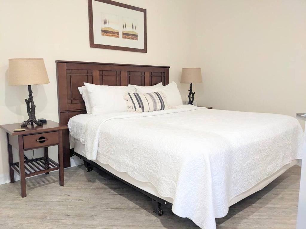 a bedroom with a large white bed with a wooden headboard at Appalachian TOP 4TH FLOOR Studio plus amazing views in Vernon Township