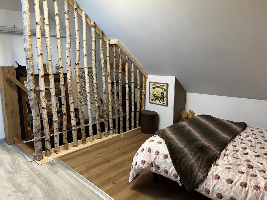 a bedroom with a bed next to a staircase at Le CappyToiT - Gîte climatisé in Cappy