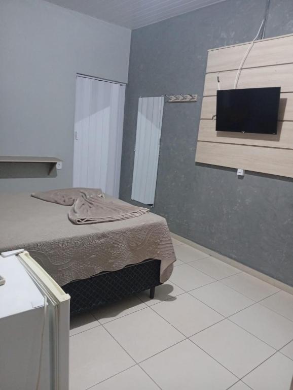 a bedroom with a bed and a flat screen tv at Restaurante e Hotel Campos in Nova Andradina