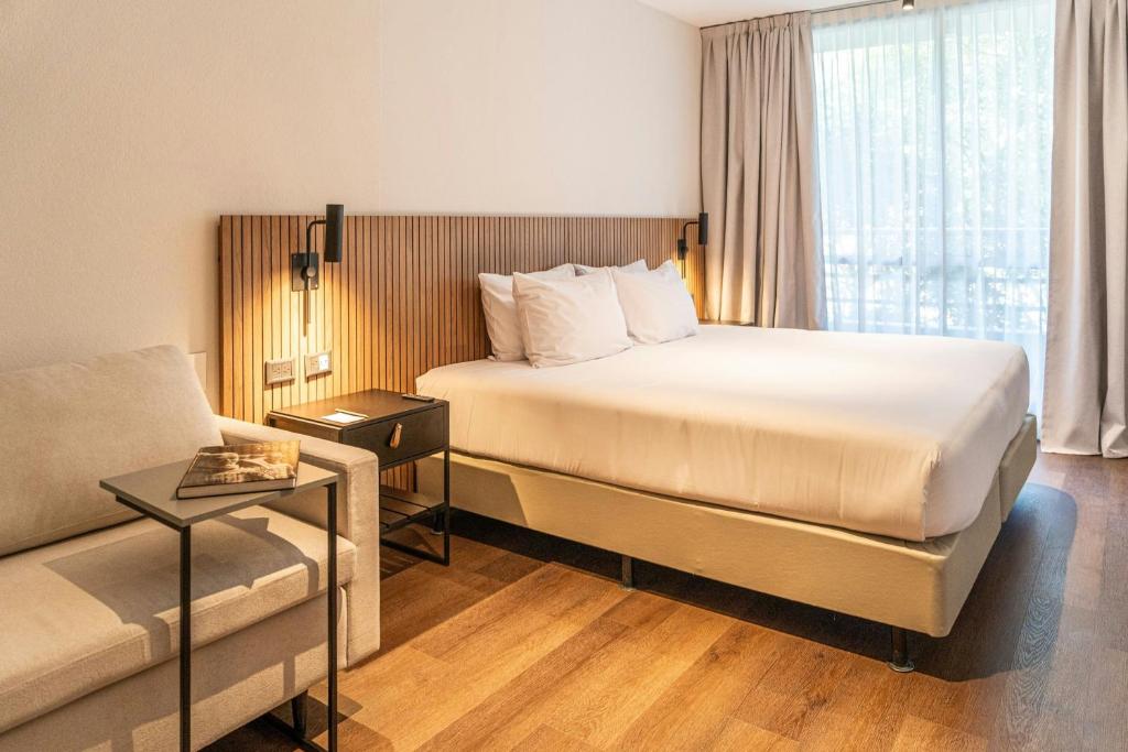 a hotel room with a bed and a couch at City Express Plus by Marriott Buenos Aires Palermo in Buenos Aires