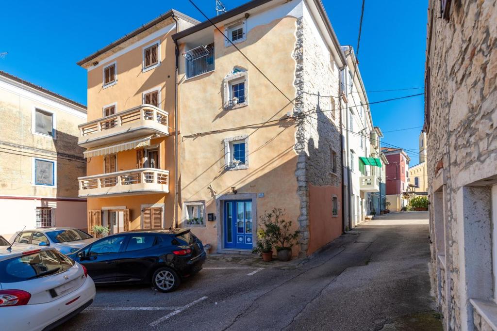 an alley with cars parked in front of a building at Casa in Centro in Brtonigla