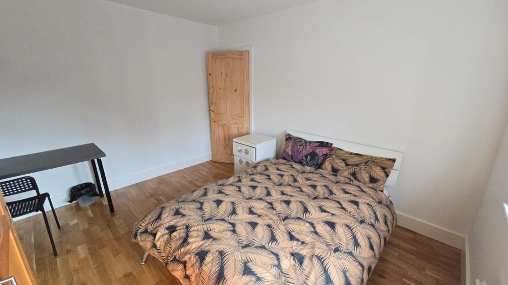 a bedroom with a bed with a comforter at Bitterne Homestay in Southampton