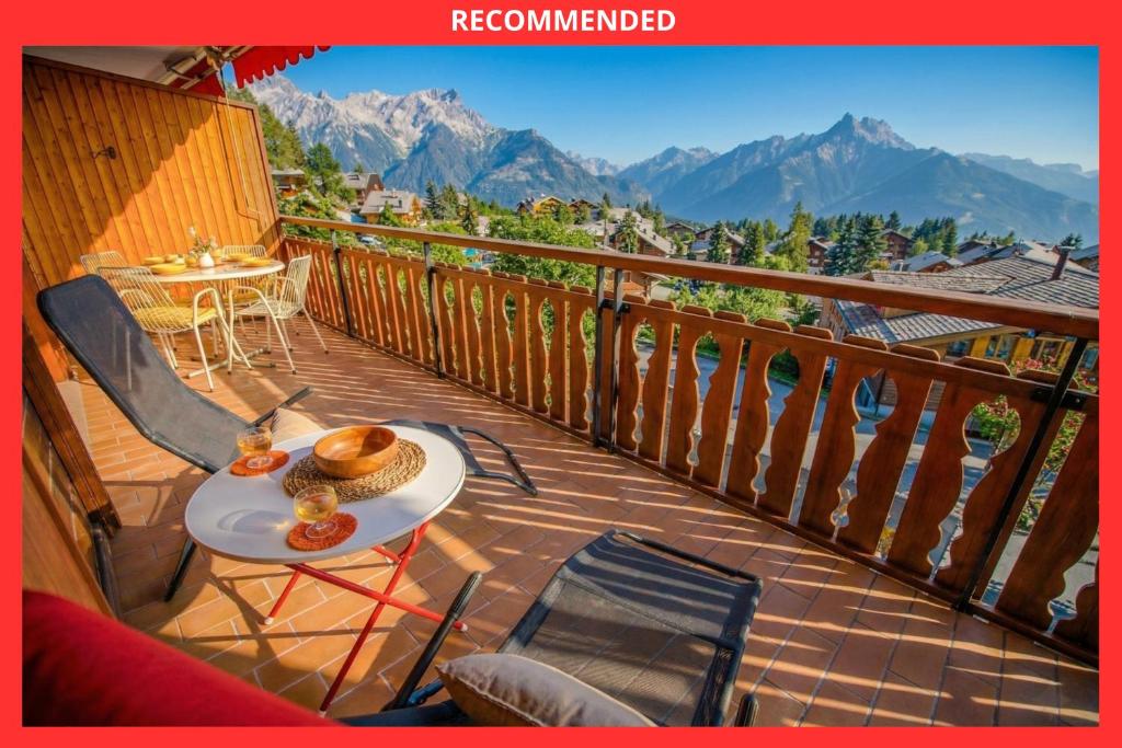 a table and chairs on a balcony with mountains at Mountain view Balcony et comfort in Ollon