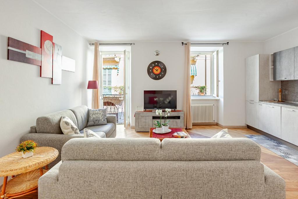 a living room with a couch and a tv at ARONA STORICO SYC Favoloso 2CAMERE 2BAGNI in Arona