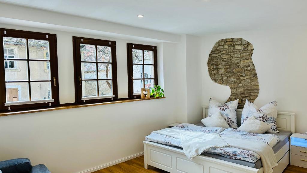 a bedroom with white walls and windows and a bed at Kalkgold Refugium in Kitzingen