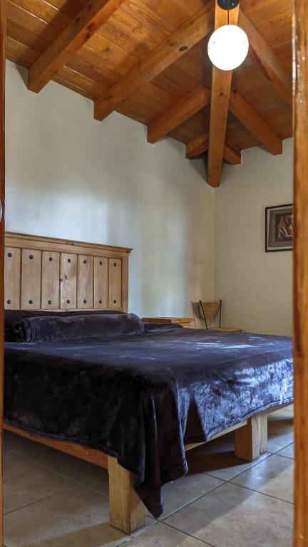 a large bed in a room with wooden ceilings at Cabaña Andrea y Sofía in Mazamitla