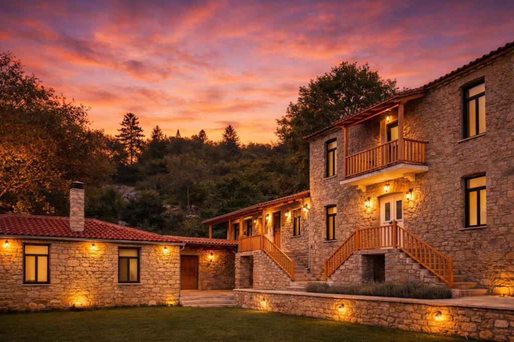 ein Steinhaus mit einem Sonnenuntergang im Hintergrund in der Unterkunft Kanalia Suites in Kanália