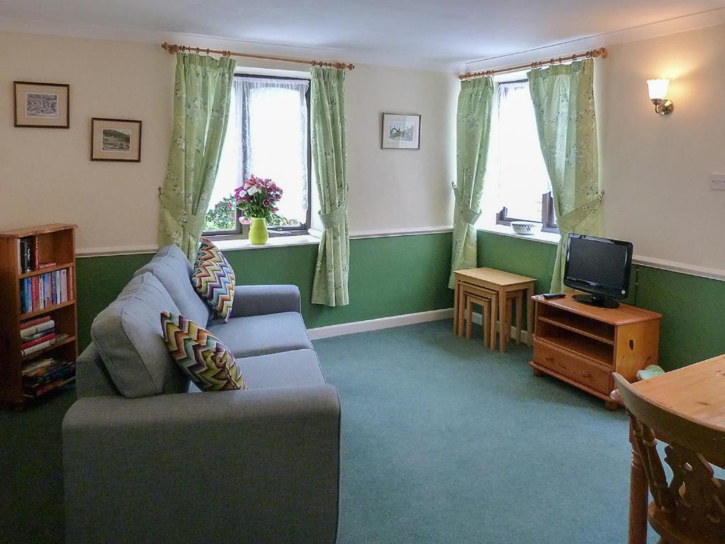 a living room with a couch and a tv at Juniper - 28060 in Wheddon Cross