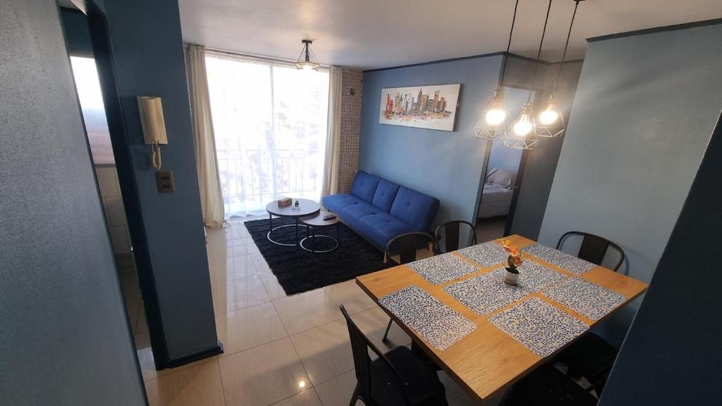 a living room with a table and a blue couch at Dpto full amoblado en copiapo 4 in Copiapó