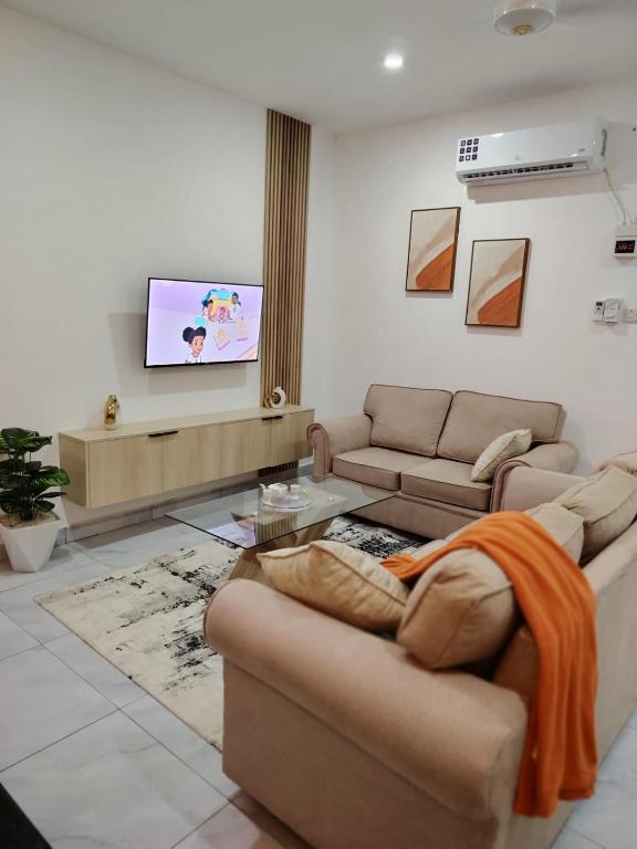 a living room with a couch and a flat screen tv at Nyali luxe 1 bedroom in Nyali