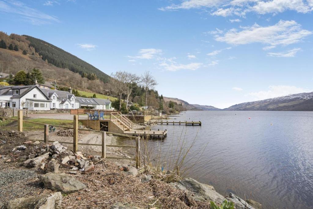 a view of a lake with a house and a dock at 3 Bed in Lochearnhead oc-c33641 in Lochearnhead
