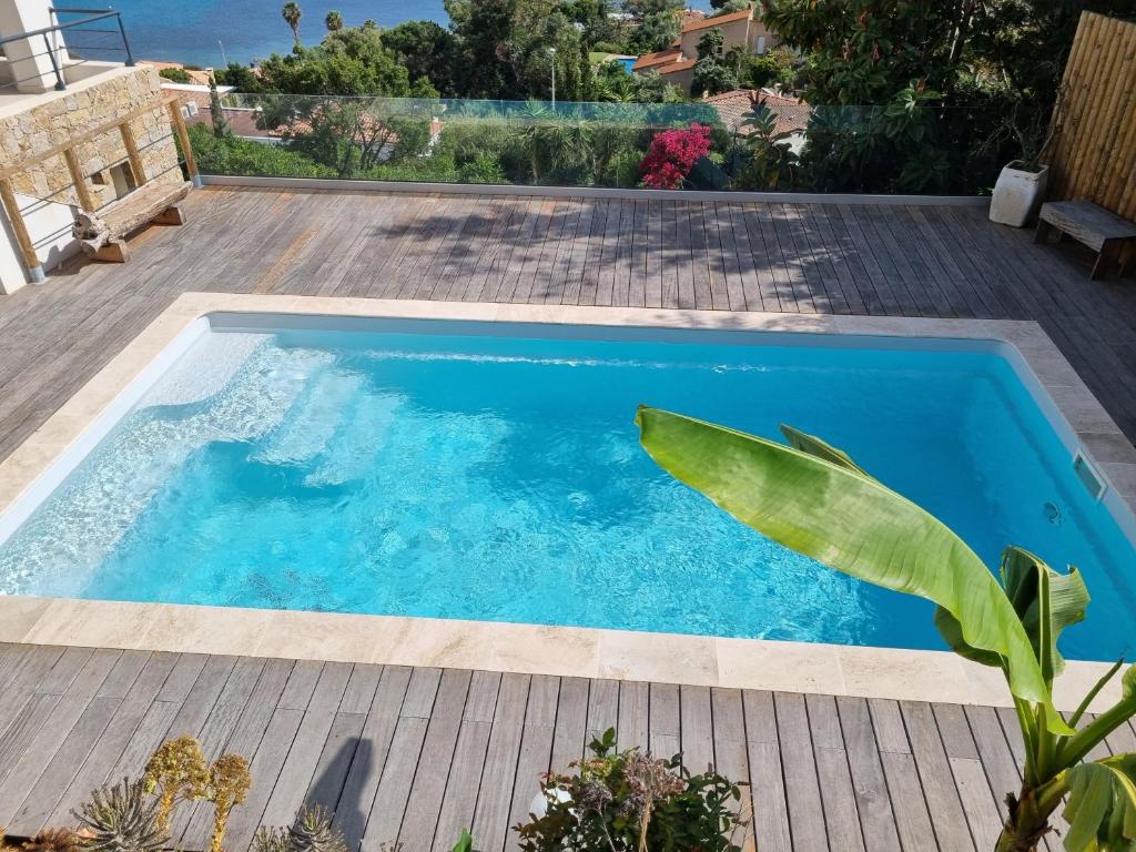 a swimming pool in a backyard with a wooden deck at Ajaccio Sanguinaires in Ajaccio