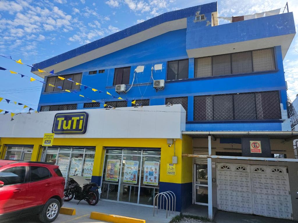 a blue building with a car parked in front of it at Hostal Haziel in Salinas