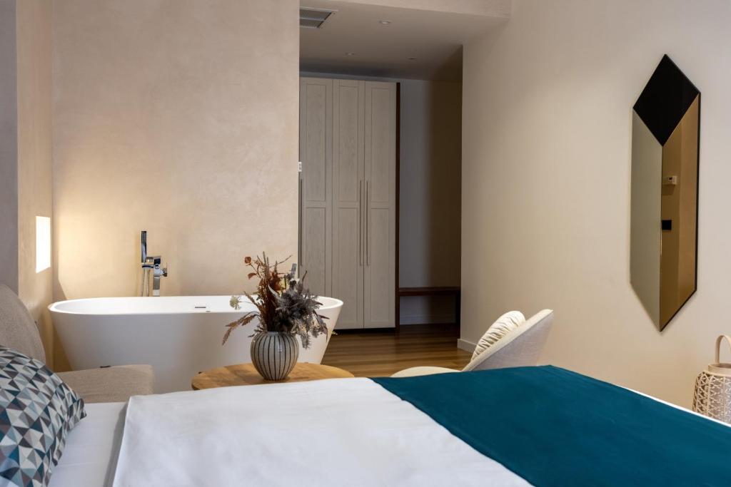 a bedroom with a bed and a bath tub at Golden City Boutique Hotel Tirana in Tirana