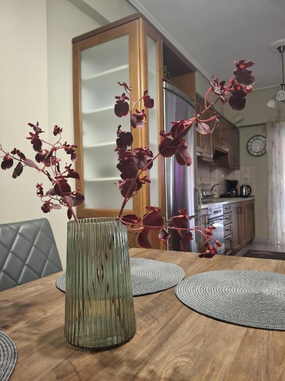 a wooden table with a vase with flowers in it at Central Home in Kalamata