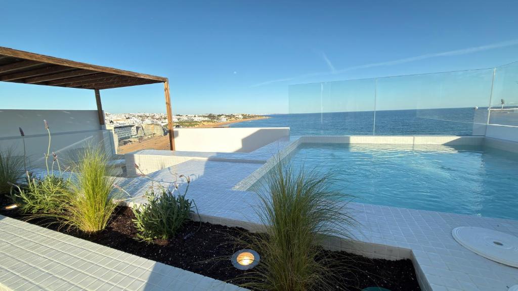 a swimming pool with a view of the ocean at Apartamentos Rossio Mar in Albufeira